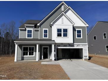 Two-story home with gray siding, white trim, and a spacious driveway leading to a two-car garage at 548 Jocund St # 15, Rolesville, NC 27571