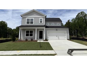 Charming two-story home with a gray exterior, a well-manicured lawn and a two car garage at 564 Jocund St # 11, Rolesville, NC 27571