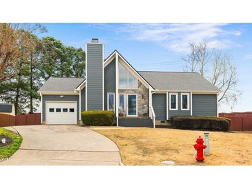 Charming gray home with stone accents, manicured lawn, and attached garage at 809 Handel Ln, Apex, NC 27502