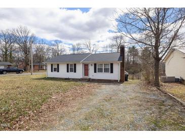 Charming single-story home with a red front door, black shutters, and a well-maintained yard at 825 Parkwood St, Burlington, NC 27215
