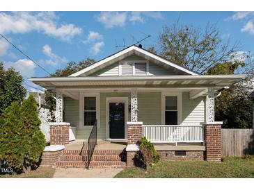Charming bungalow with a covered front porch with brick and decorative columns at 907 Holloway St, Durham, NC 27701