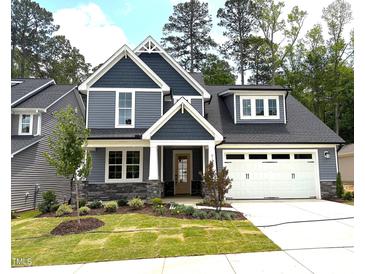 Charming two-story home with a manicured lawn, stone accents, and a spacious two-car garage at 9160 Dupree Meadow Dr # 13, Angier, NC 27501