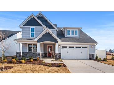 Charming two-story home featuring stone accents, a red front door, and a two-car garage with detailed trim at 9160 Dupree Meadow Dr # 13, Angier, NC 27501