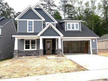 New two-story home with blue siding, stone accents, covered entry, and attached two car garage at 9160 Dupree Meadow Dr # 13, Angier, NC 27501