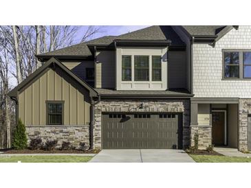 Modern townhome exterior with stone accents, two-car garage, and well-manicured lawn, offering a stylish curb appeal at 970 Double Helix Rd, Apex, NC 27523