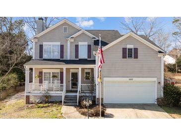 Charming home featuring a covered front porch, attached garage, and neat landscaping at 1007 Olde Midway Ct, Knightdale, NC 27545