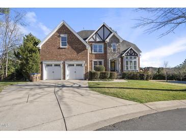 Charming brick and stone home with a well-manicured lawn and a two-car garage at 1104 Fanning Dr, Wake Forest, NC 27587