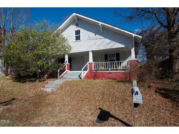 Charming two-story home with white siding, red foundation, and landscaped front yard and mailbox at 1805 Shelton Ave, Durham, NC 27707