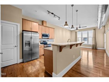 Modern kitchen features stainless steel appliances, granite countertops, and an island with pendant lighting at 300 Finsbury St # 313, Durham, NC 27703