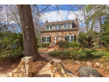 Charming two-story home with a brick path, beautiful landscaping, and multiple windows at 300 Mccauley St, Chapel Hill, NC 27516