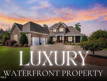 Stunning brick waterfront home featuring manicured landscaping, stone accents, and a circular driveway at 309 Shoreline Dr, Princeton, NC 27569