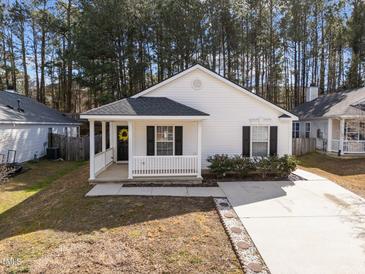 Charming single-story home featuring a lovely front porch and well-manicured landscaping at 312 Homestead Park Dr, Apex, NC 27502