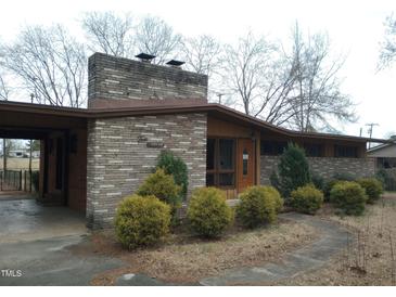 Charming single-story brick home with mature landscaping and covered carport at 410 W Barrington St, Dunn, NC 28334