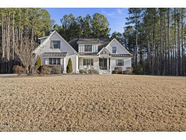 Stunning white brick two-story home with a well-manicured lawn and a welcoming front porch at 5609 Abbey Grace Ln, Wake Forest, NC 27587