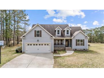 Charming two-story home with attached garage and well-maintained lawn on a sunny day at 64 Old Barn Way, Wendell, NC 27591