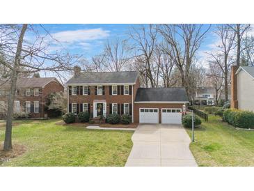 Charming two-story brick home with a well-maintained front yard and two-car garage at 810 Warwick Ct, Burlington, NC 27215