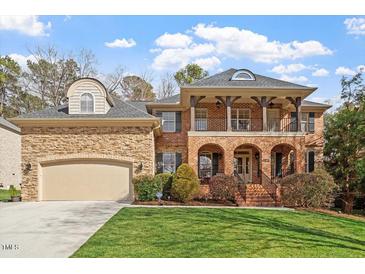 Charming two-story brick home featuring a manicured lawn and a welcoming front porch at 8912 Riverview Park Dr, Raleigh, NC 27613