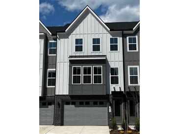 Modern townhome exterior with gray siding, attached garages, and neatly trimmed landscaping at 1011 Regalia Rd # 29, Durham, NC 27713