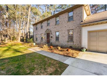 Charming two-story brick home featuring a well-manicured lawn, and attached garage at 1201 Deerfield Dr, Cary, NC 27511
