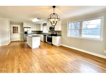 Spacious kitchen with white cabinets, stainless steel appliances, granite counters and hardwood floors at 128 Barclay Rd, Durham, NC 27712