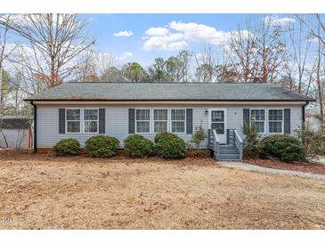 Charming single-story home featuring a well-maintained lawn, tidy bushes, and a welcoming entryway at 129 Shawnee Dr, Louisburg, NC 27549