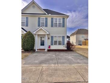Charming townhome featuring light yellow siding and blue shutters, with a concrete driveway and tidy landscaping at 2323 Turtle Point Dr, Raleigh, NC 27604