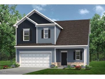 Charming two-story home with blue siding, a well-manicured lawn, and an attached two-car garage at 253 Deodora Ln, Cameron, NC 28326