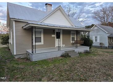 Charming single-Gathering home with a covered front porch and swing, steps, and manicured lawn at 301 Wilson St, Franklinton, NC 27525