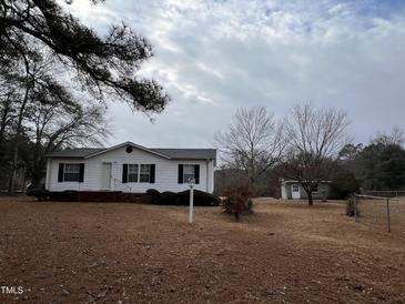 Cozy home featuring manicured landscaping, a charming birdhouse, and a spacious yard at 3211 Kipling Rd, Fuquay Varina, NC 27526