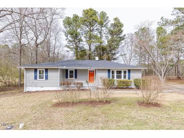 Charming single-story home with gray siding, blue shutters, and a vibrant orange front door at 4814 Fayetteville Rd, Durham, NC 27713
