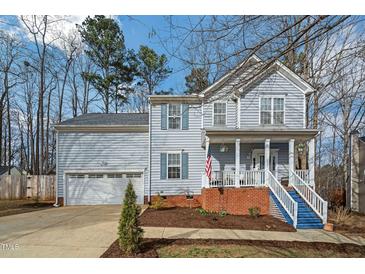 Charming two-story home with light blue siding, blue shutters, and a welcoming front porch with blue painted steps at 507 Town Crier Ct, Hillsborough, NC 27278
