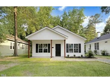 Charming single-story home with white siding, black shutters, and a well-maintained front yard at 5512 Hickory Ln, Raleigh, NC 27603