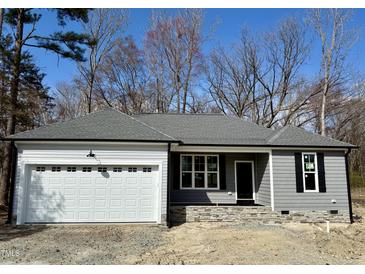 Charming single-story home featuring a gray exterior, attached garage, and stone accents near the entrance at 600 Hicksmill Rd, Oxford, NC 27565