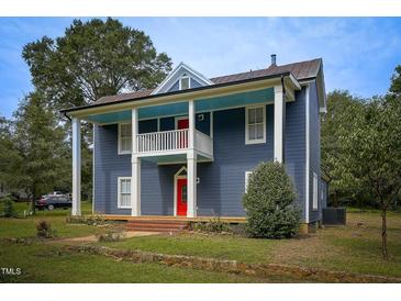Charming two-story home features blue siding, red doors, and a quaint porch at 613 Mclean St, Spring Hope, NC 27882