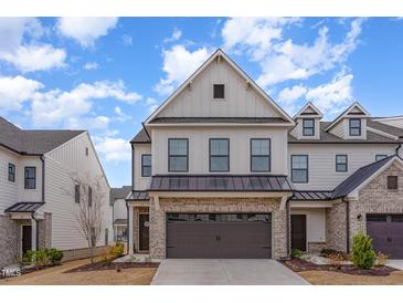 Beautiful two-story townhome with a brick garage, situated on a quiet street under a partly cloudy sky at 94 Paperwhite Pl, Clayton, NC 27527