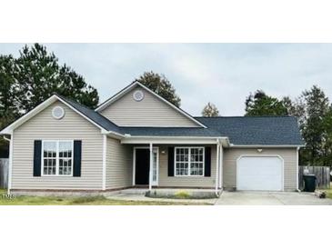 Charming single-story home featuring light siding, black shutters, and a well-maintained front yard at 104 Ginger Cir, Selma, NC 27576