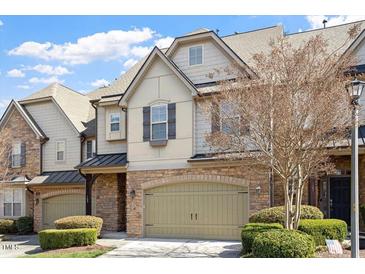 Charming townhome featuring a two-car garage, stone accents, and well-maintained landscaping at 105 Sunstone Dr, Cary, NC 27519