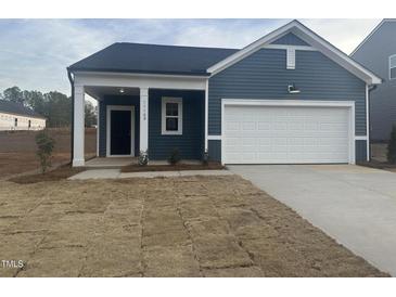 Charming single-story home with blue siding, a white garage door, and a covered entryway at 11186 Salers Loop, Middlesex, NC 27557