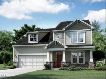 Charming two-story home with a manicured lawn, an attached two-car garage, and a welcoming red front door at 1389 Sparkling Lake Dr # 46, Apex, NC 27523