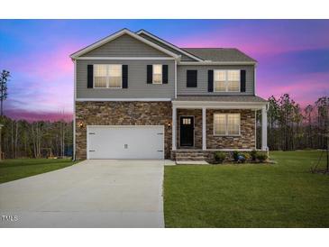 Charming two-story home featuring stone accents, gray siding, and a well-maintained lawn at 140 Baker Farm Dr, Youngsville, NC 27596