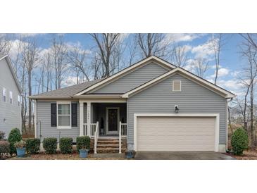 Charming single-Gathering home featuring a welcoming front porch and attached two-car garage at 1600 Frog Hollow Way, Wake Forest, NC 27587