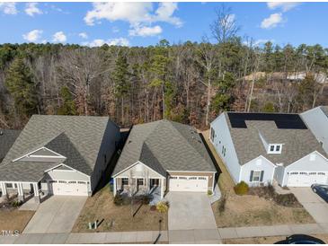 An aerial view shows a well-kept neighborhood with manicured lawns and homes backing to trees at 1713 Wrenn Rd, Durham, NC 27703