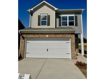 Two story home featuring an attached two car garage and brick and vinyl siding at 192 Bruce Dr, Dunn, NC 28334