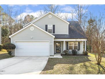 Charming two-story home with a well-manicured lawn, attached garage, and a cozy front porch sitting area at 201 Timber Meadow Lk, Fuquay Varina, NC 27526