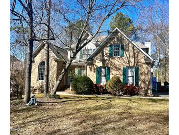 Charming brick home with green shutters and mature trees in a well-maintained yard at 300 Barthel Dr, Cary, NC 27513