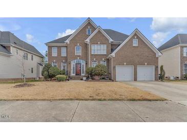 Brick two-story home with arched entry, well-manicured lawn, and a two-car garage at 505 Redford Place Dr, Rolesville, NC 27571