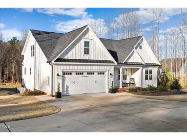 Stunning two-story home with white siding, a gray roof, and a spacious driveway, creating a charming curb appeal at 955 Lynch Rd, Selma, NC 27576