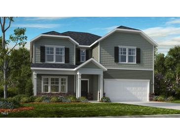 Charming two-story home features a clean color palette, attached garage, and manicured lawn at 1133 Sun Springs Rd, Wake Forest, NC 27587