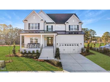 Stately two-story white brick home with a covered front porch and a two-car garage at 3176 Armeria Dr, Apex, NC 27502