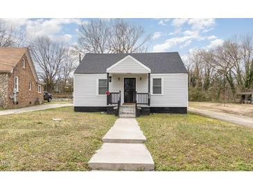 Charming home featuring a covered porch, gray siding, and a well-maintained front yard at 628 East Ave, Henderson, NC 27536